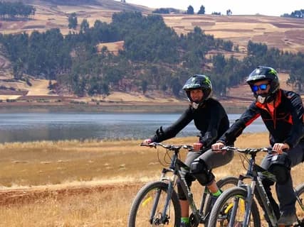Bicycles resting beside a still lake on the Deosai plains