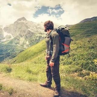 Hiker with a large backpack on a mountain trail
